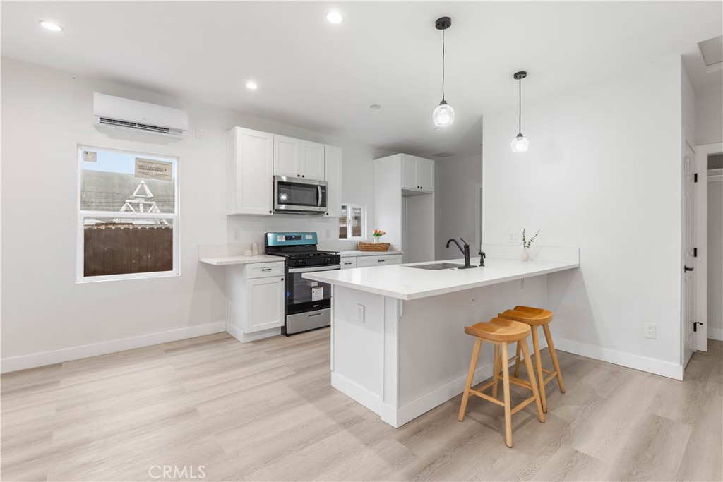 a kitchen with kitchen island a sink cabinets and stainless steel appliances