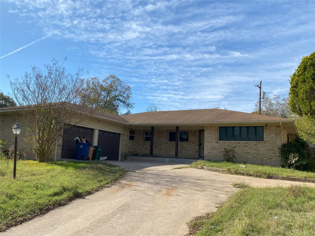 a front view of a house with a garden and yard