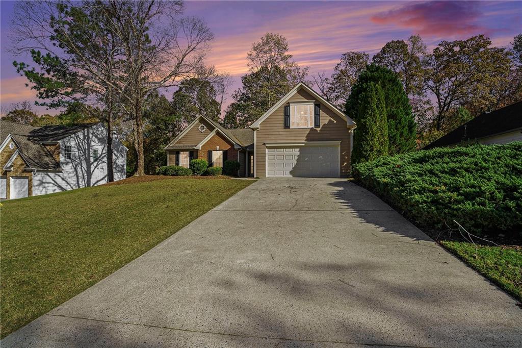 a front view of a house with a yard and trees