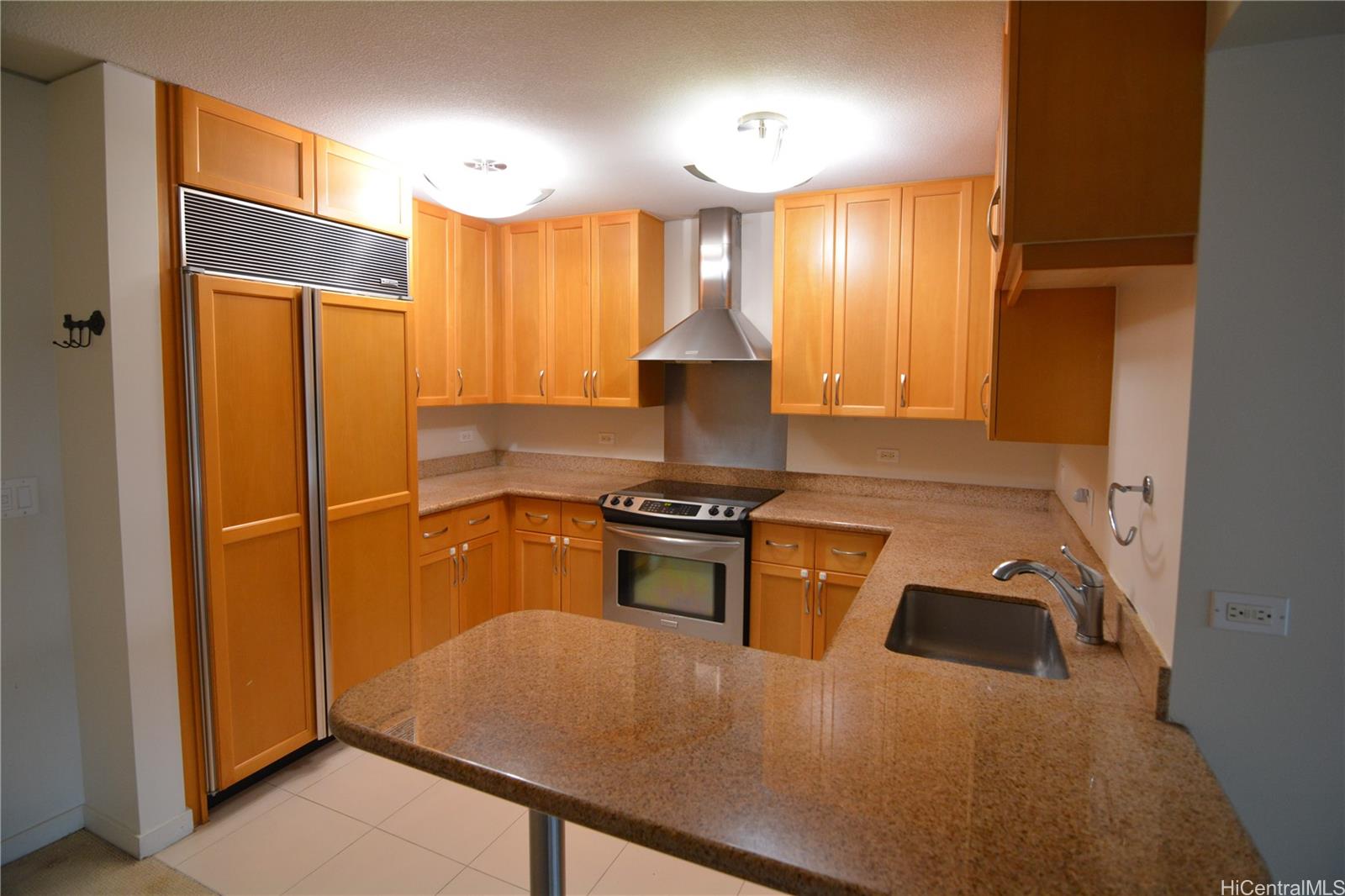 a kitchen with stainless steel appliances granite countertop a stove a refrigerator and a sink