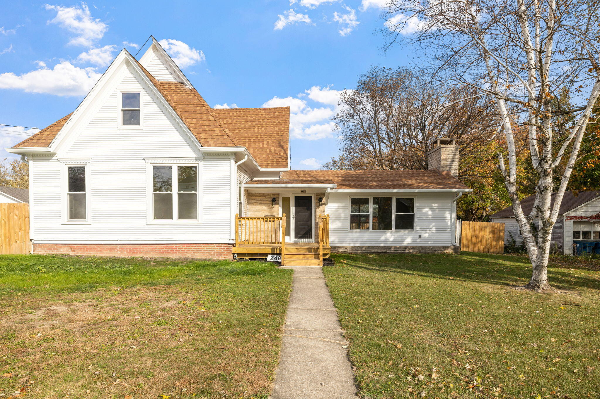 a front view of a house with a yard and trees