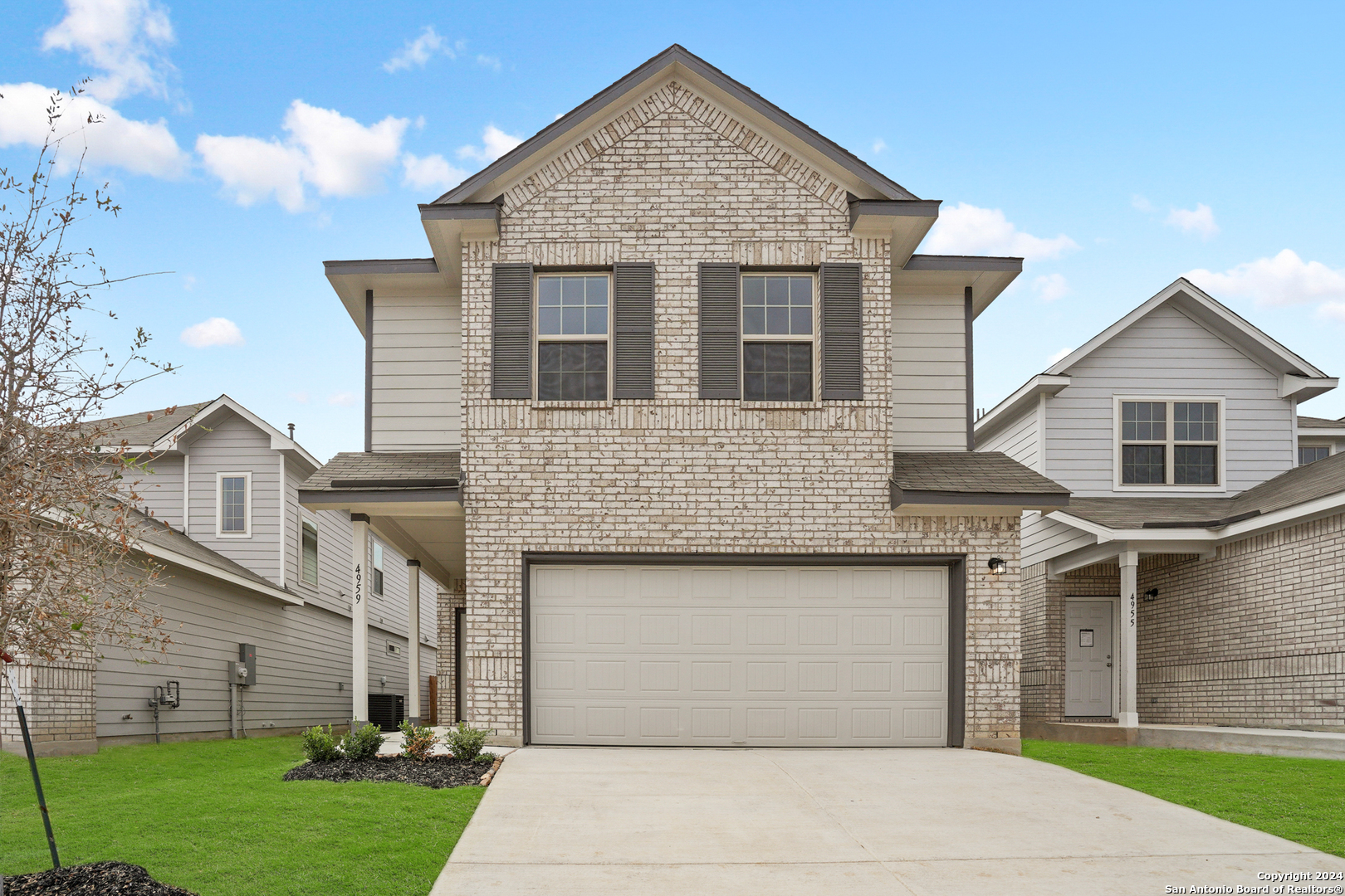 a front view of a house with a garden and garage