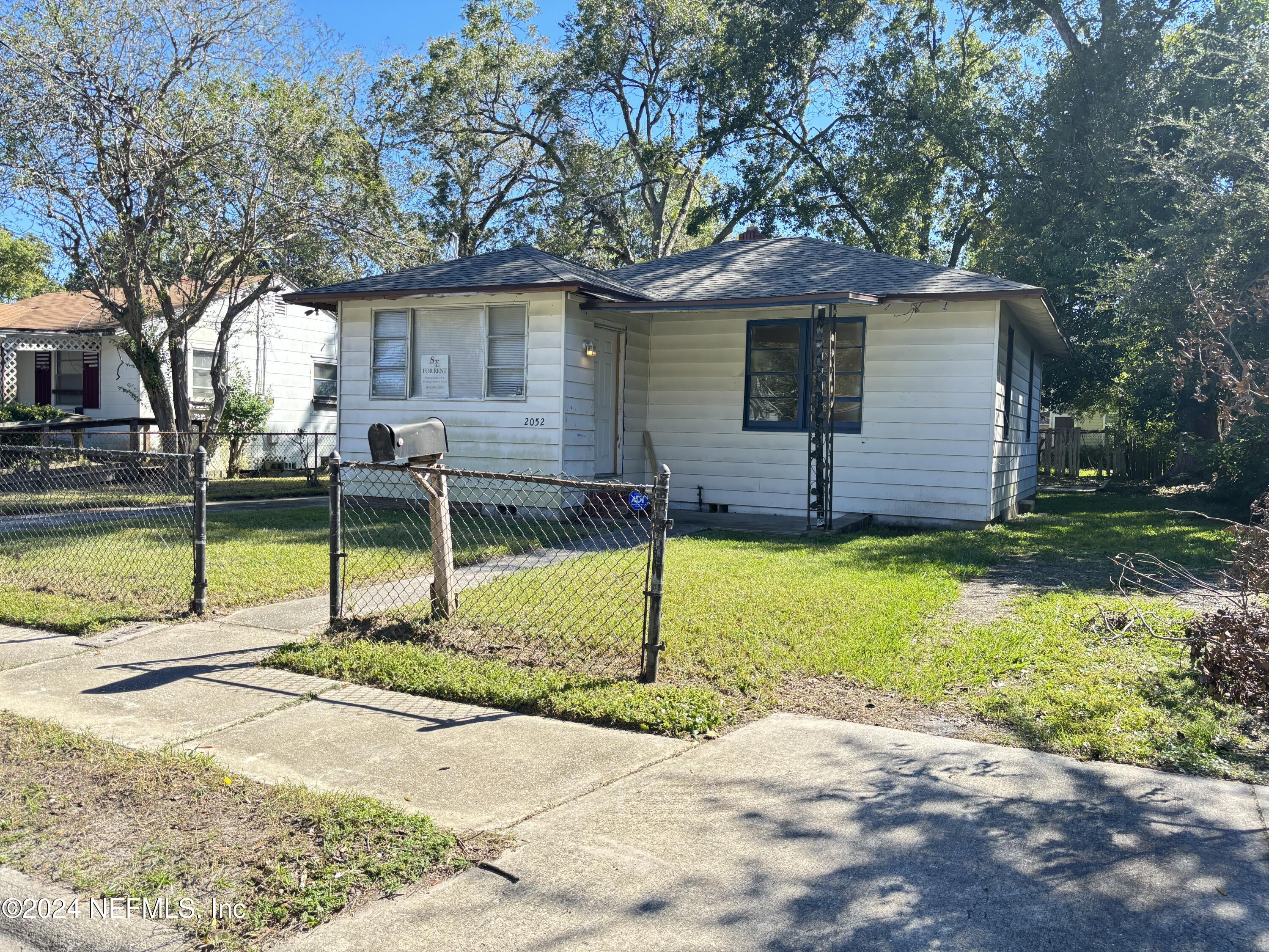 a view of a house with backyard and tree