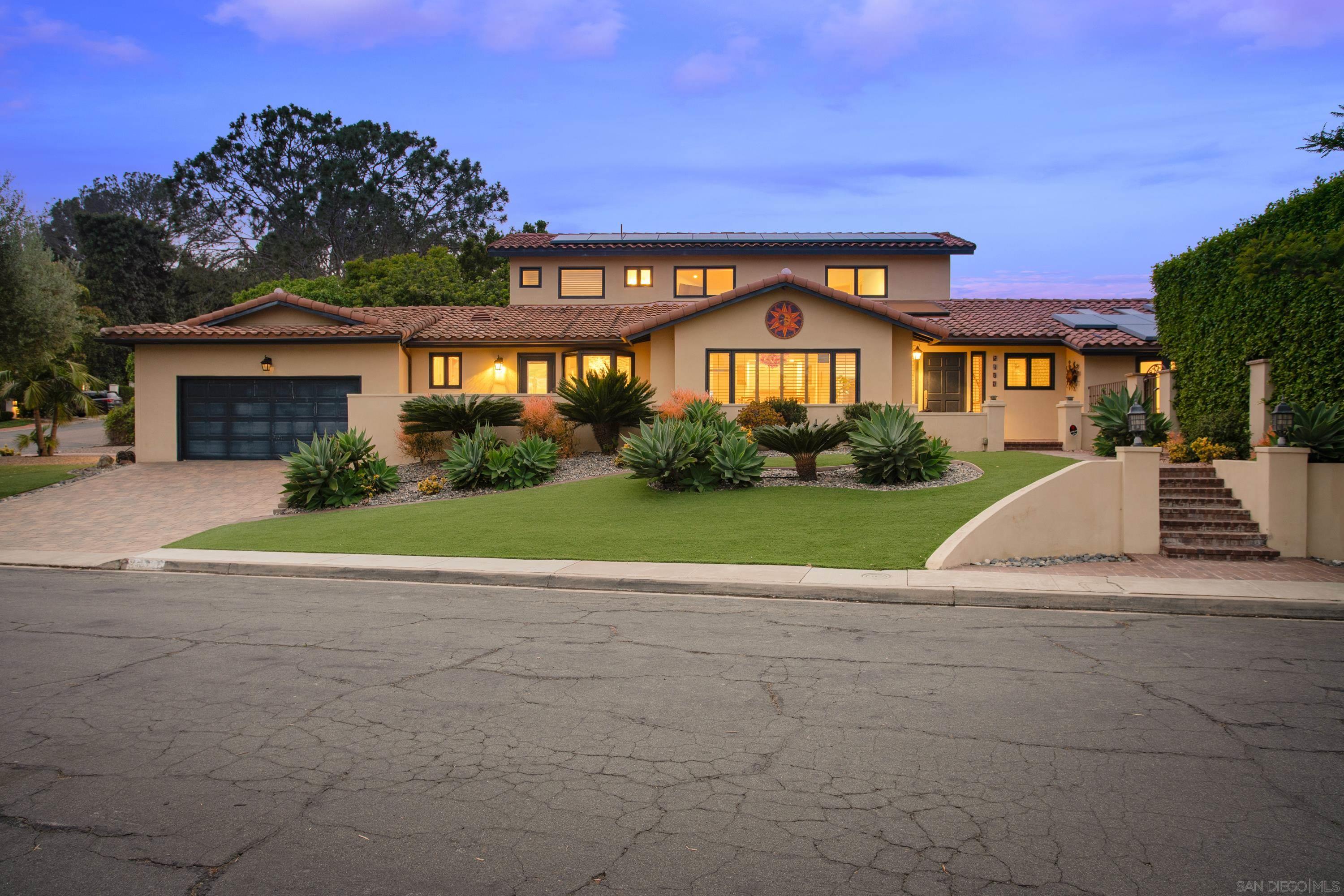 a view of a big building with a big yard and large trees