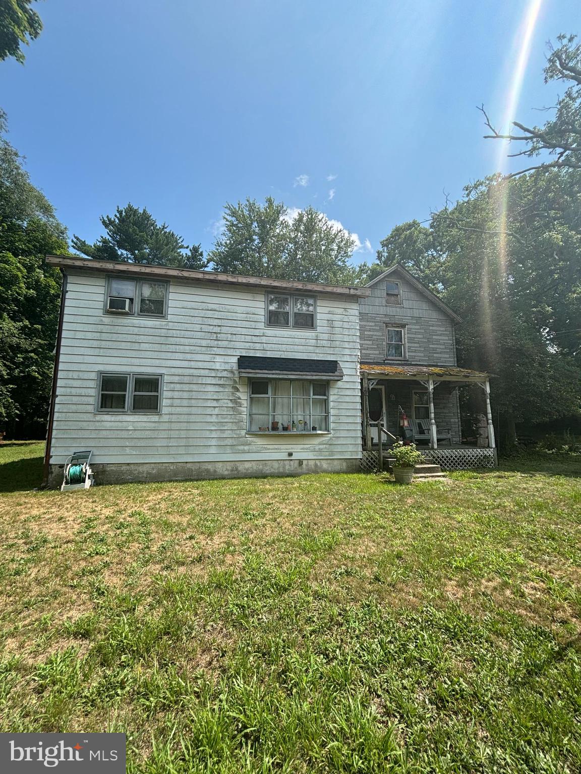 a front view of house with yard and trees in the background