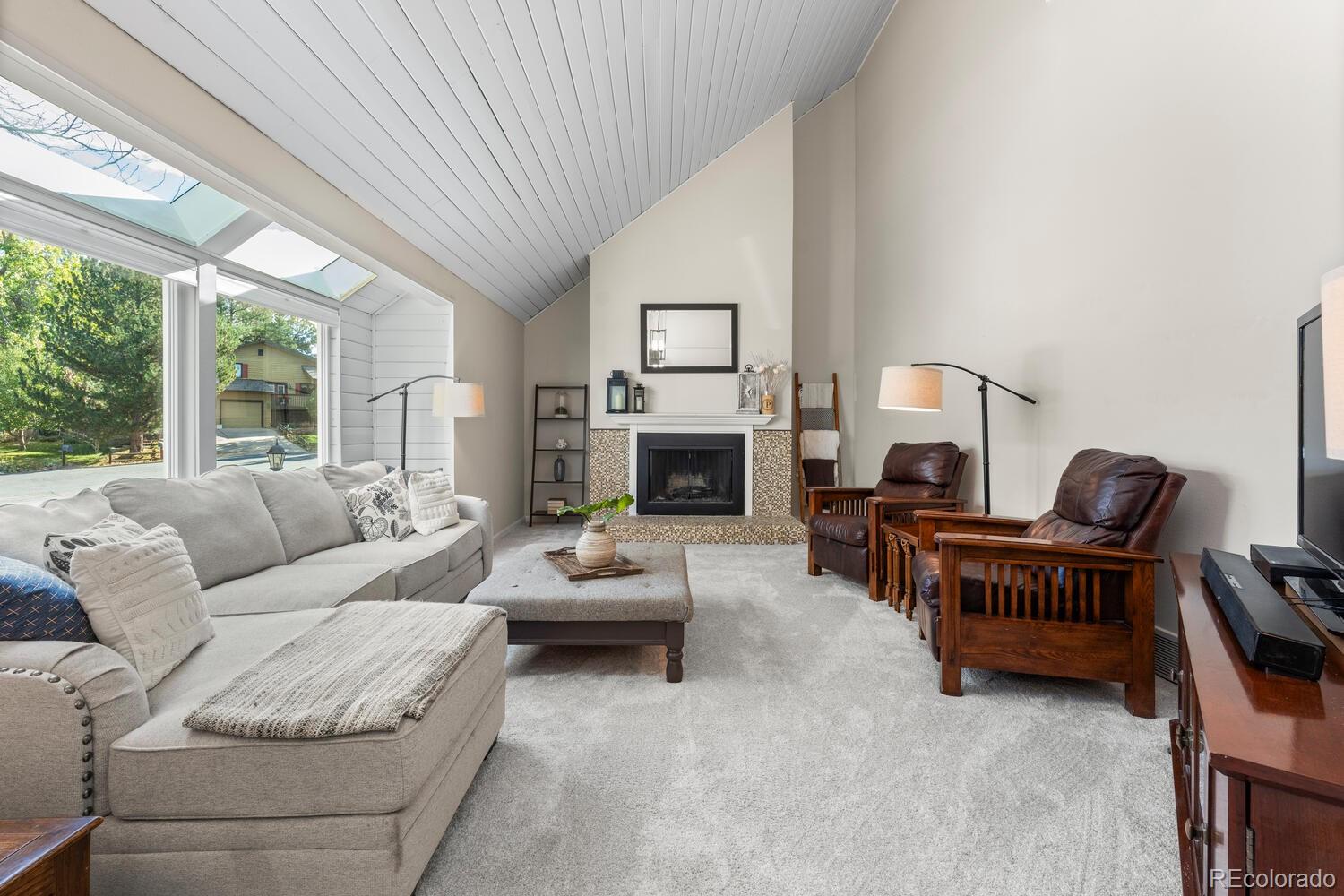 a living room with furniture a fireplace and a large window