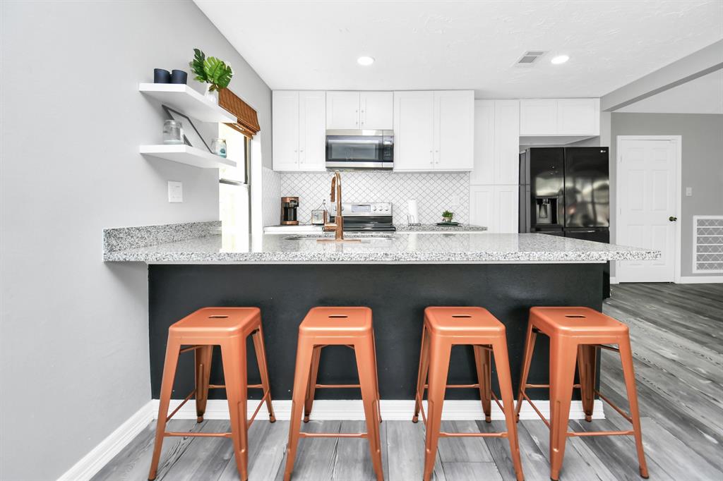 a kitchen with a dining table chairs and wooden floor