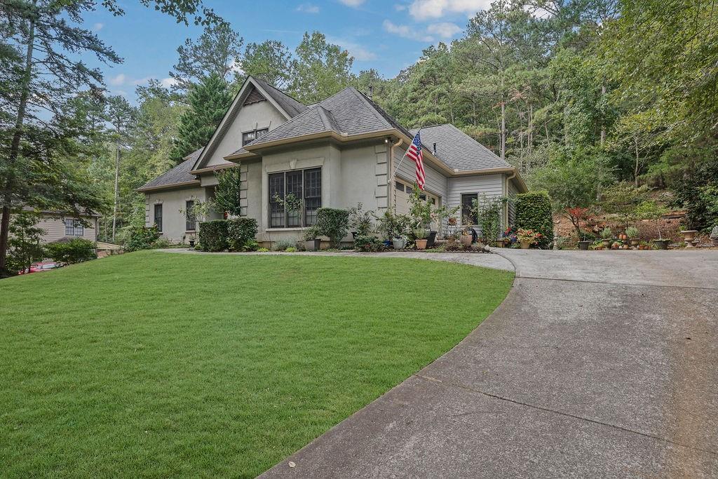 a front view of a house with a yard and trees