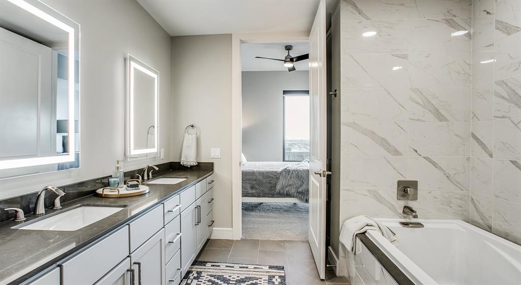 a spacious bathroom with a tub sink and mirror