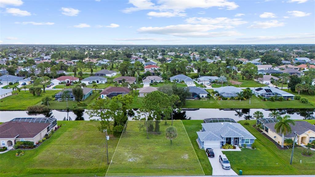 an aerial view of residential houses with outdoor space and trees