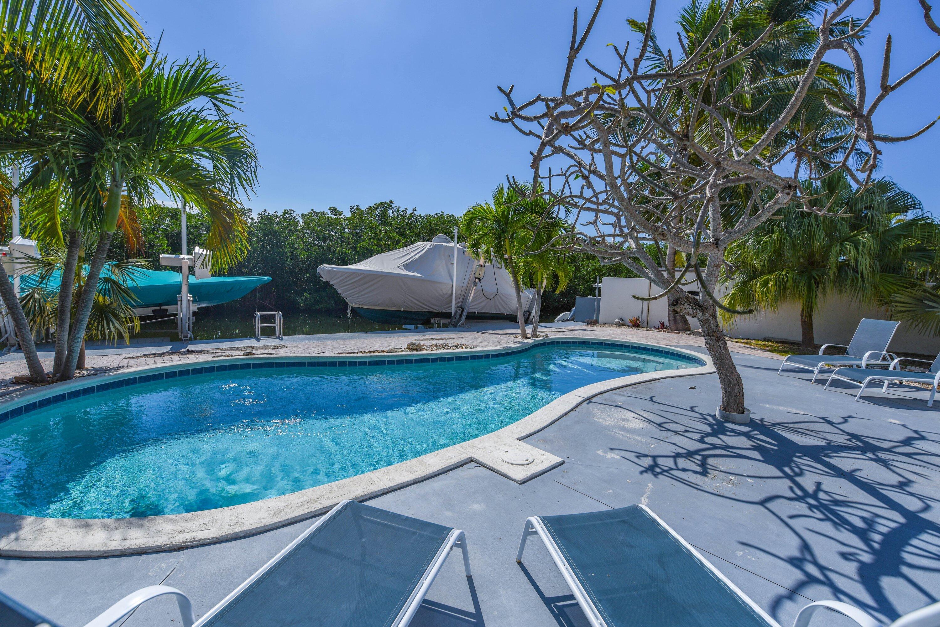 a view of a backyard with swimming pool