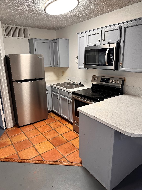 a kitchen with stainless steel appliances a refrigerator a stove a microwave a sink and cabinets