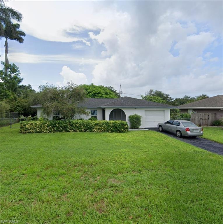 Single story home with a garage and a front lawn