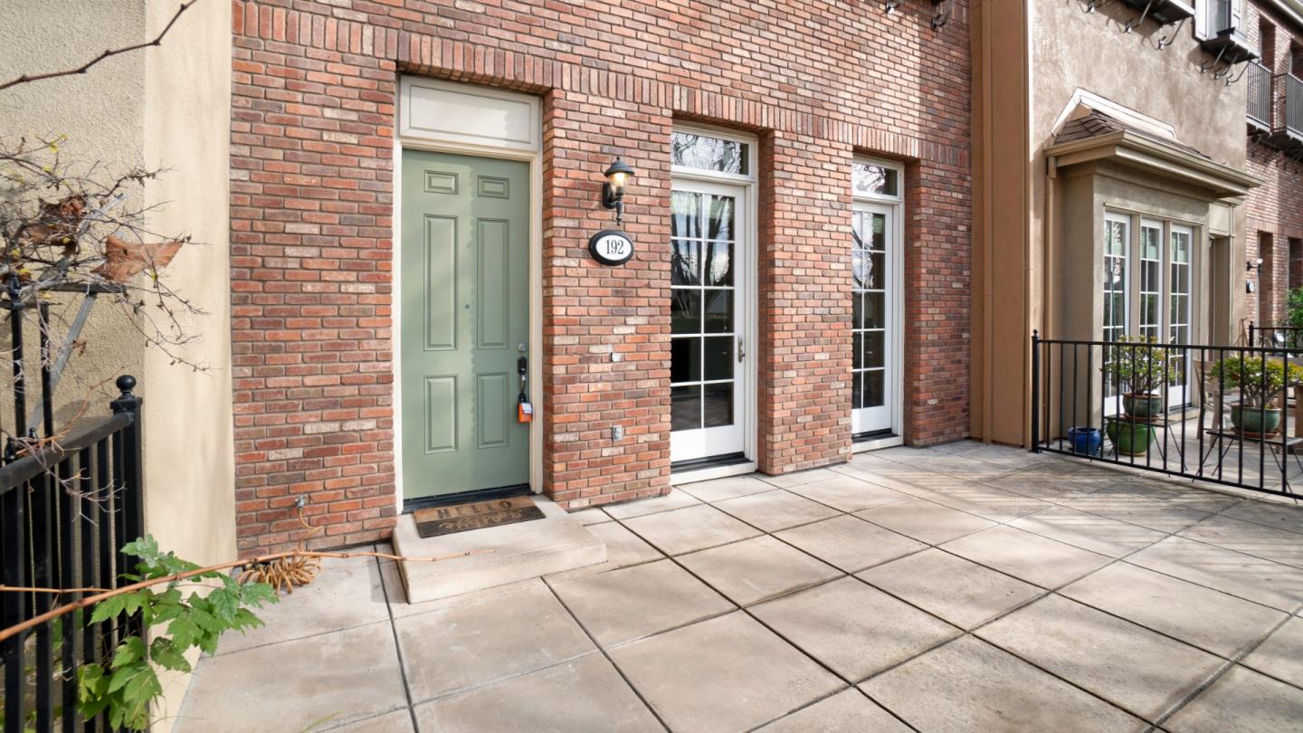 a view of a brick house with a bench and a potted plant