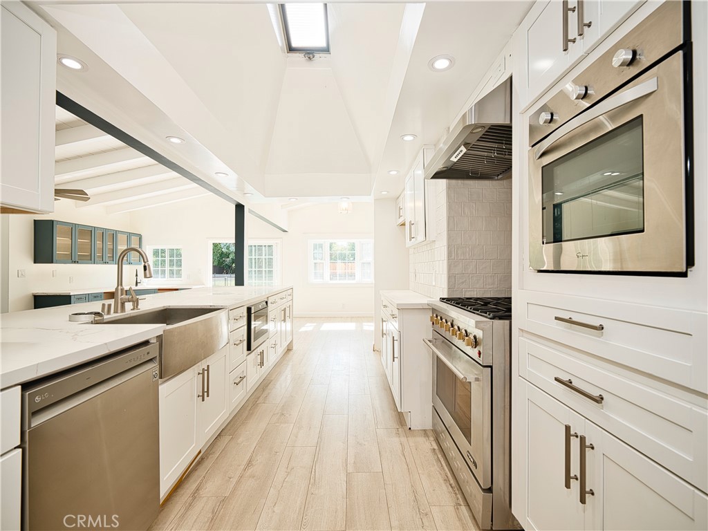 a kitchen with granite countertop a stove top oven sink and cabinets