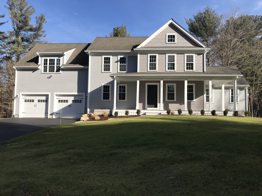 a front view of a house with a garden and lake view