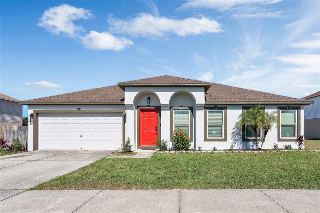 a front view of a house with a yard and garage