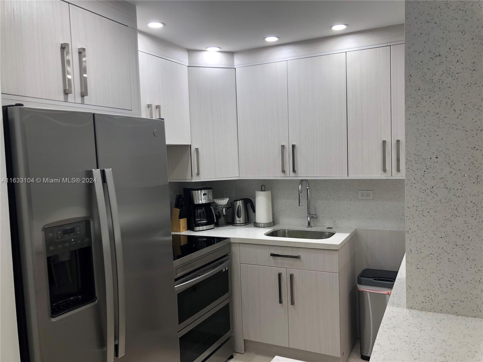 a kitchen with a sink stainless steel appliances and cabinets