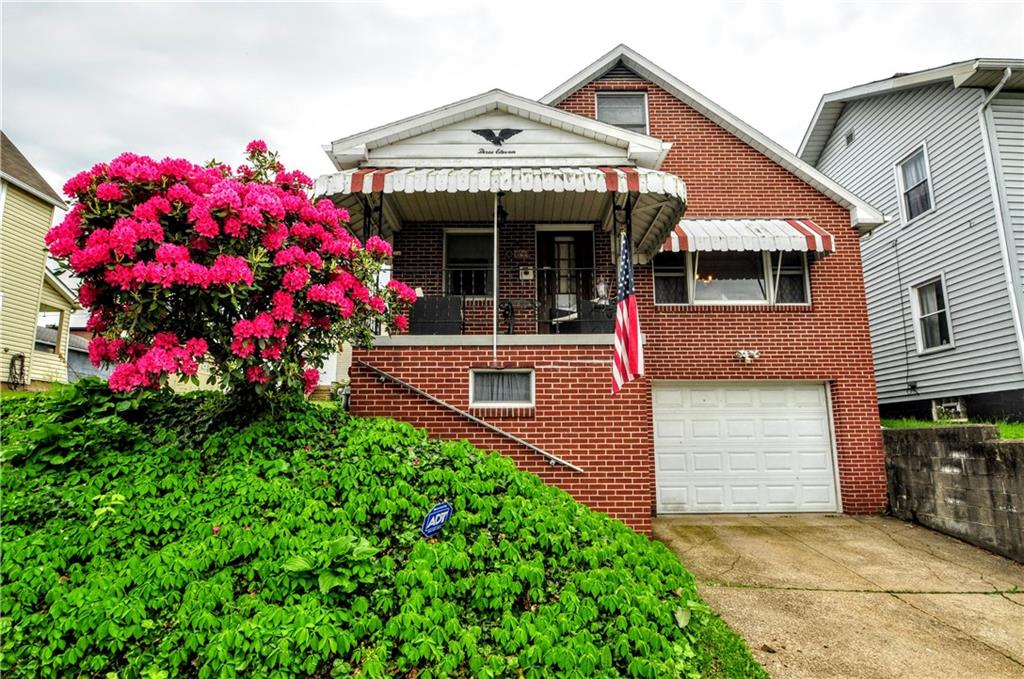 a front view of a house with lots of flower plants