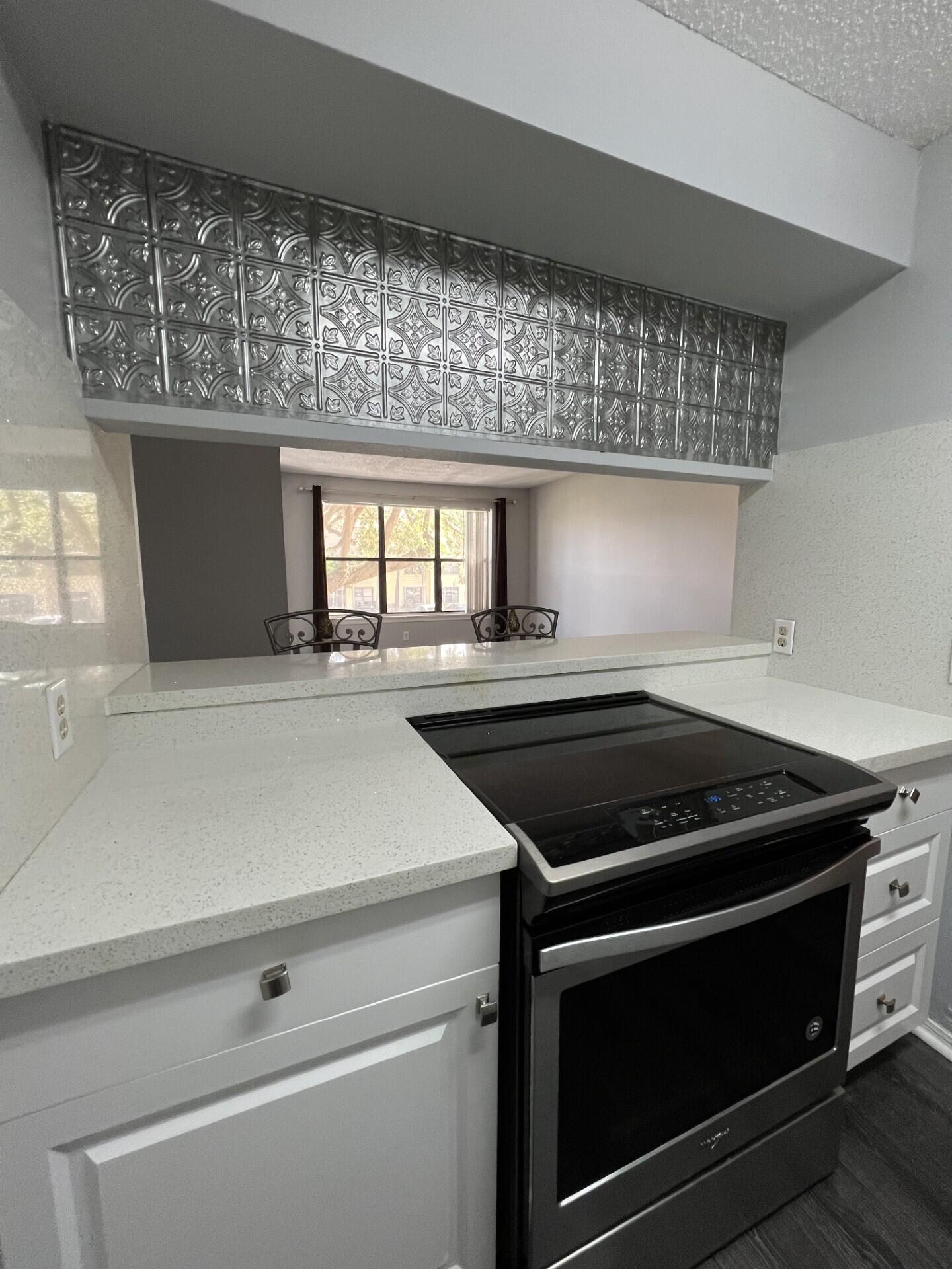 a kitchen with granite countertop a stove and a microwave