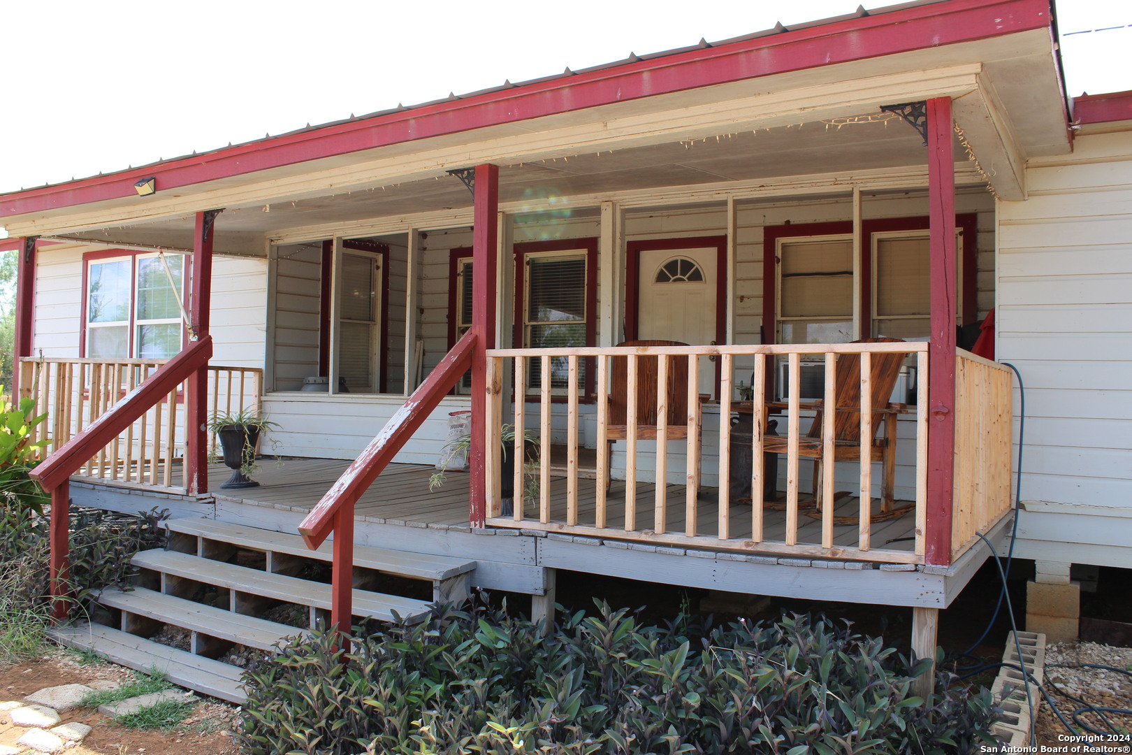 a view of a house with wooden deck and furniture