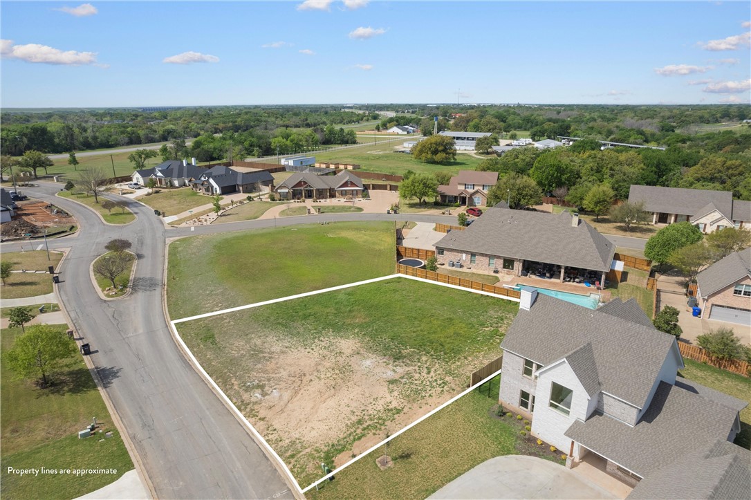 an aerial view of a house with outdoor space and a lake view in back