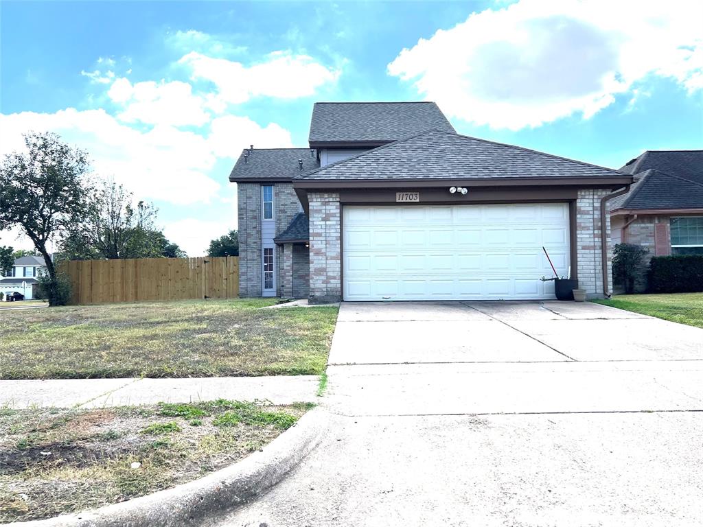 a front view of a house with a garden and garage