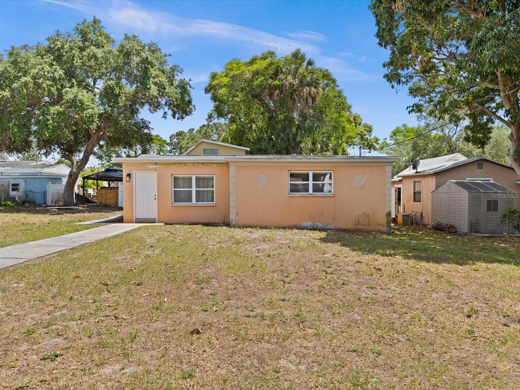 a view of a house with a backyard and a tree