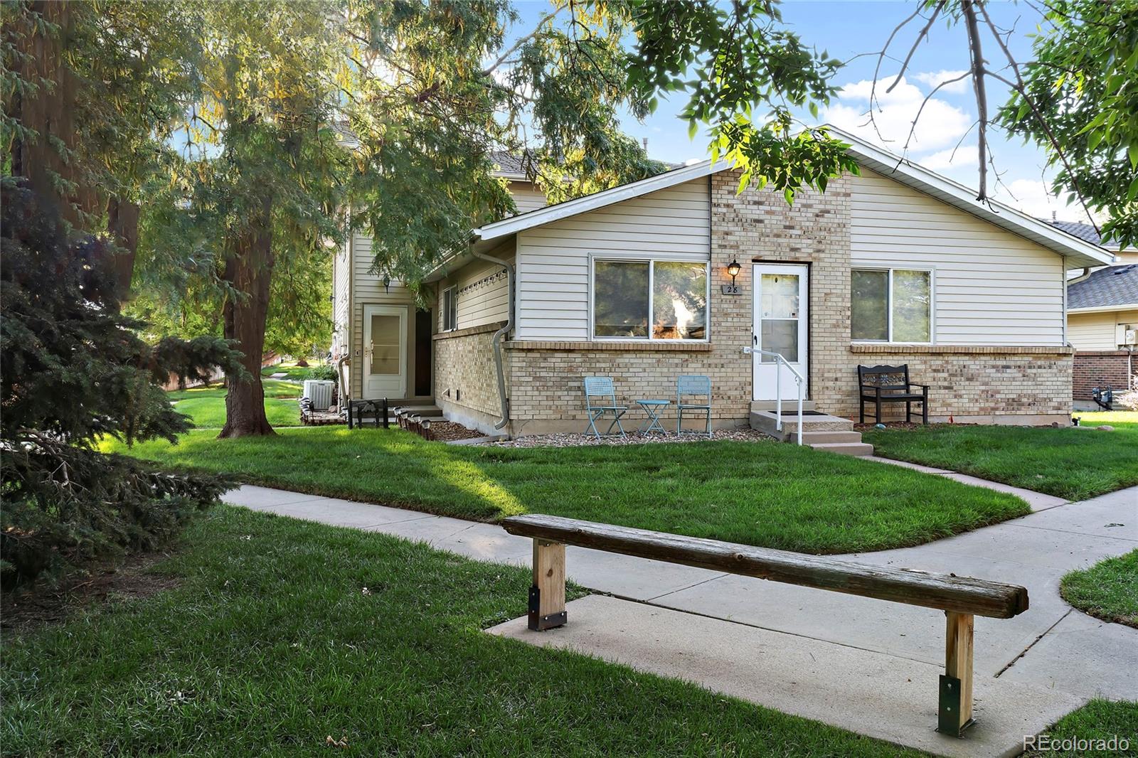 a view of a yard in front of a house with a large tree