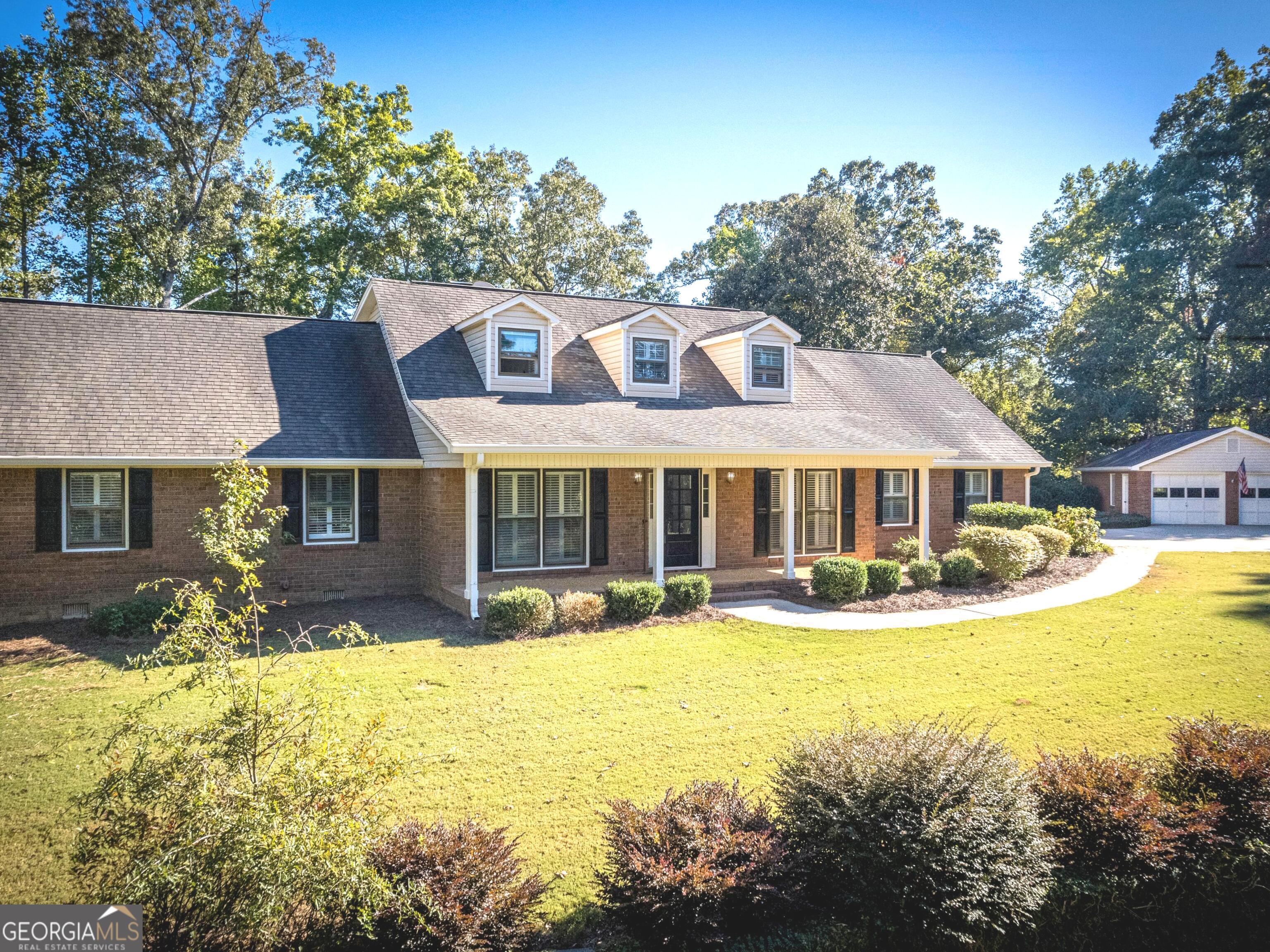 a front view of house with yard and trees in the background