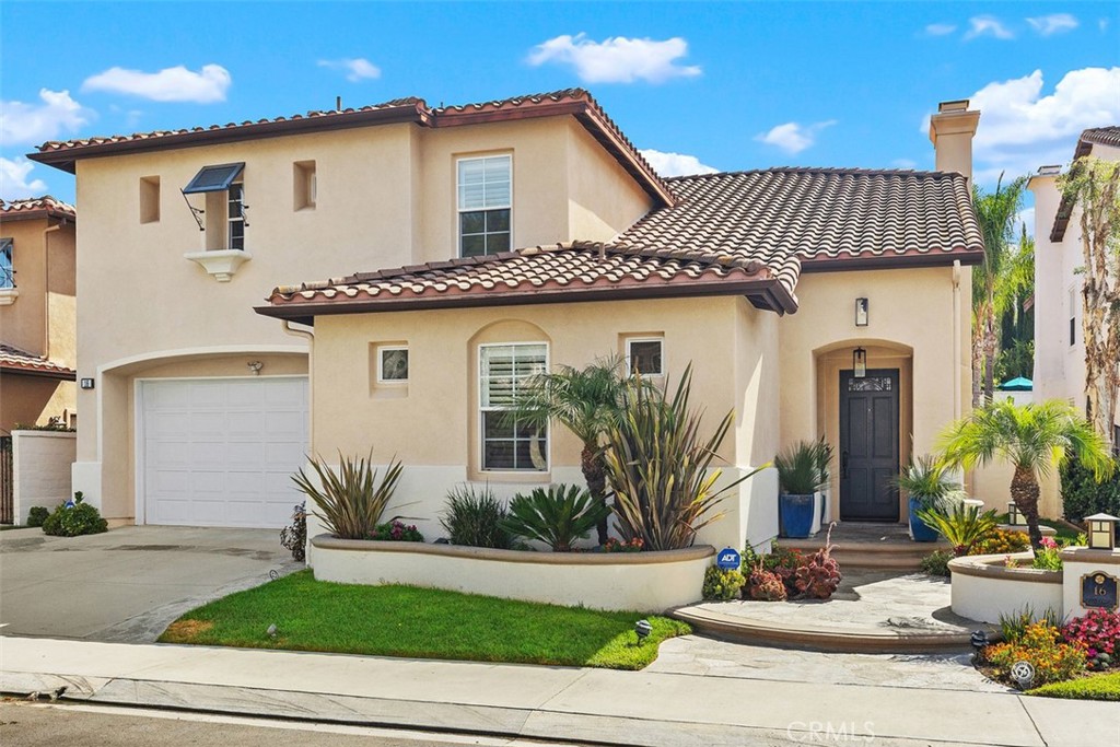 a front view of a house with garage and plants