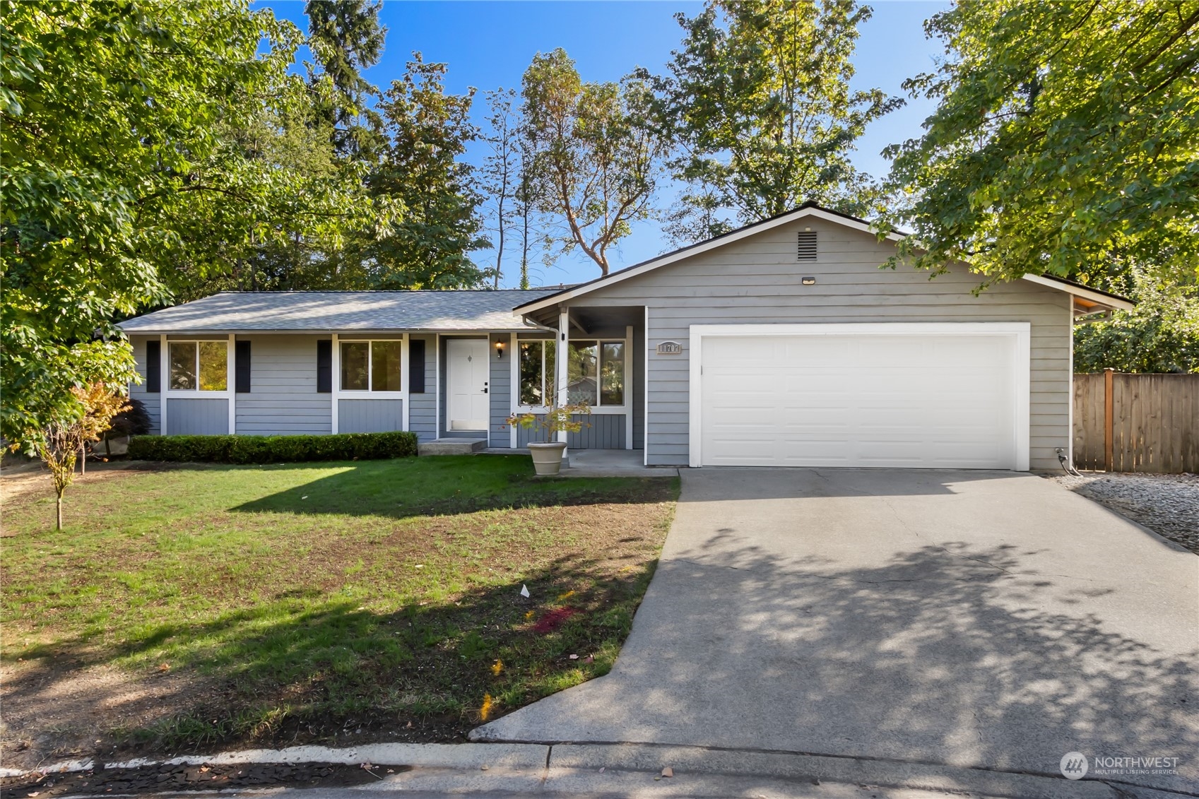 a front view of house with yard and trees in the background