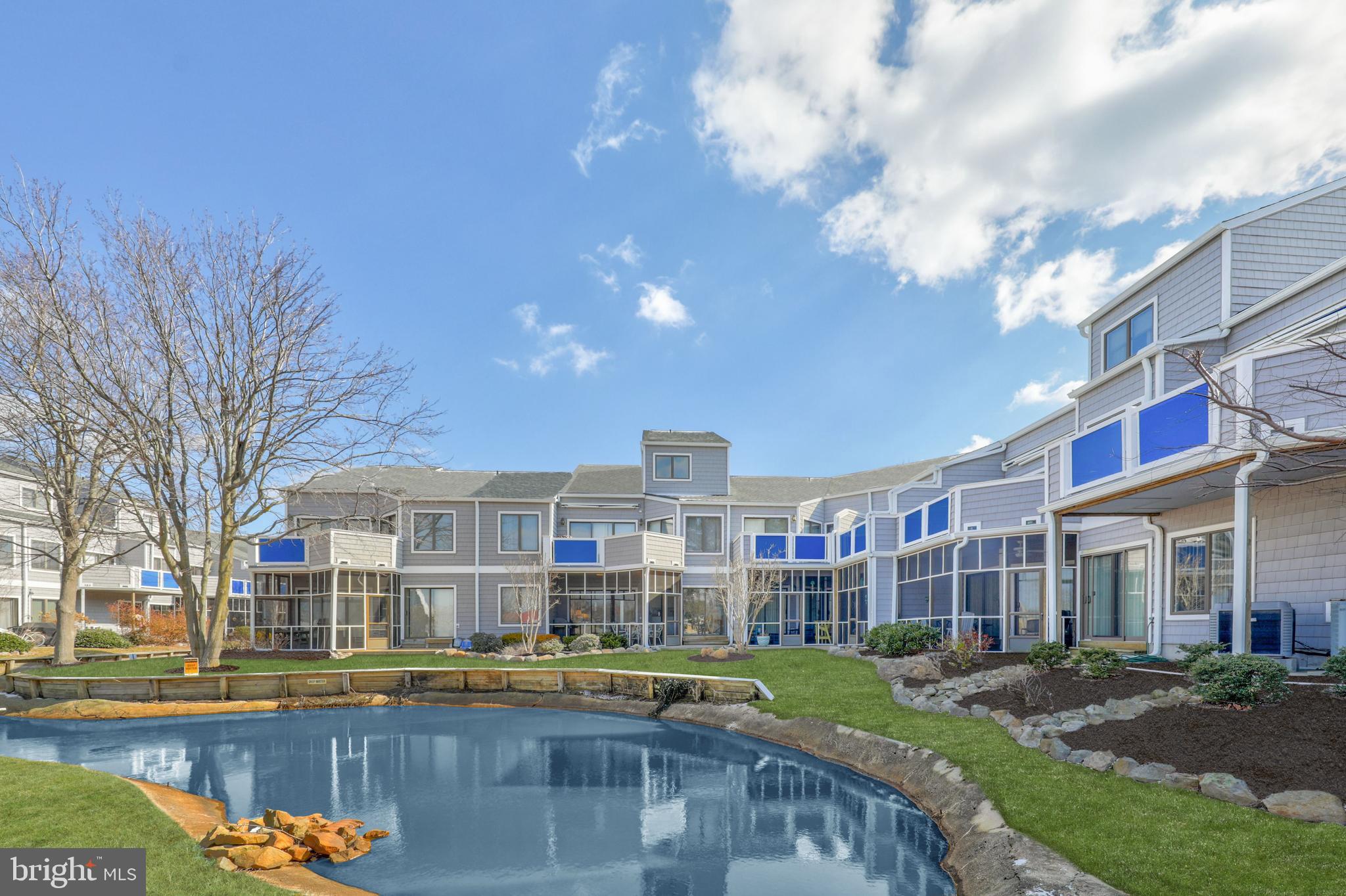 a front view of a building with lake view and trees