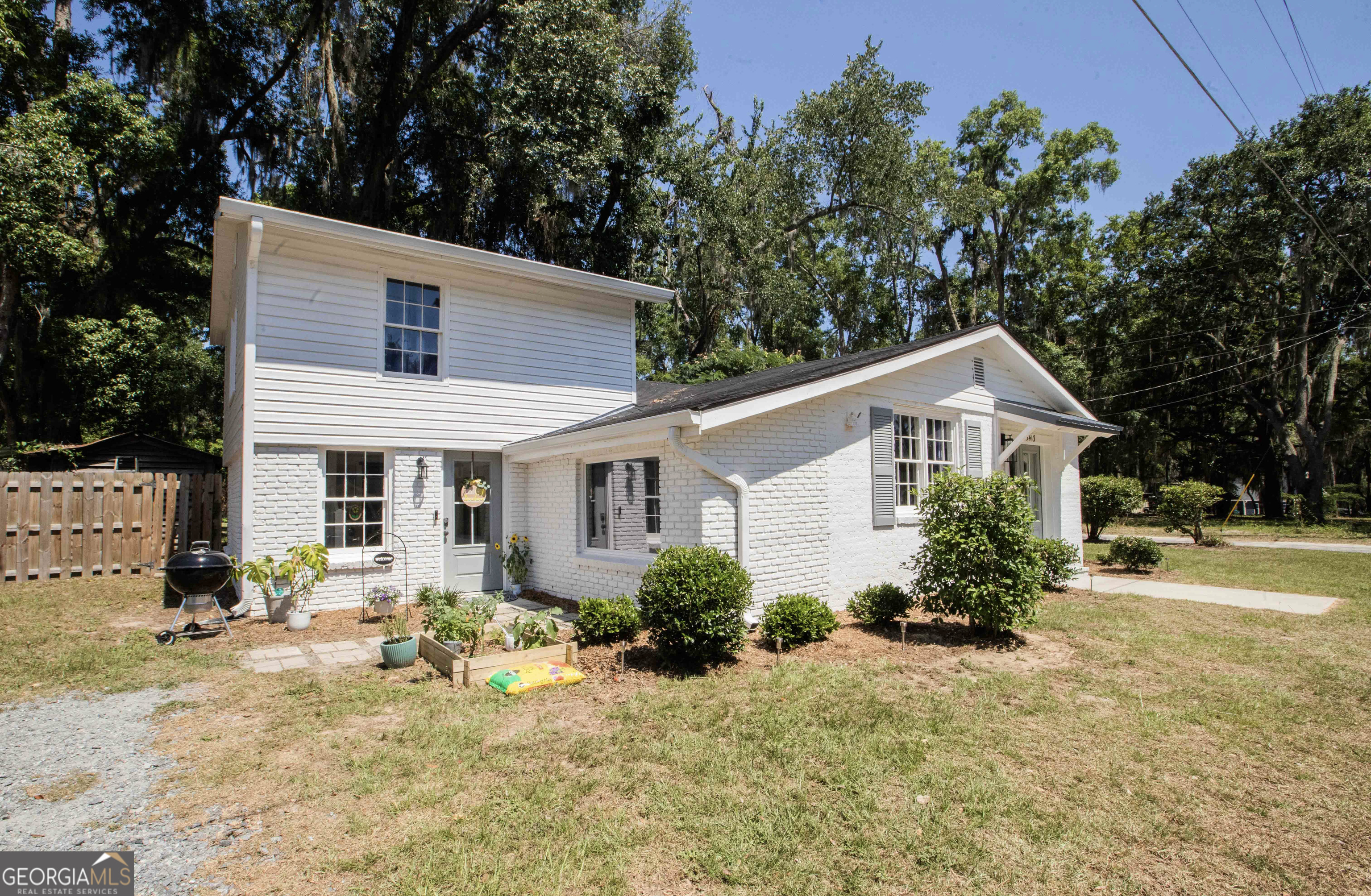 a front view of house with yard and trees around