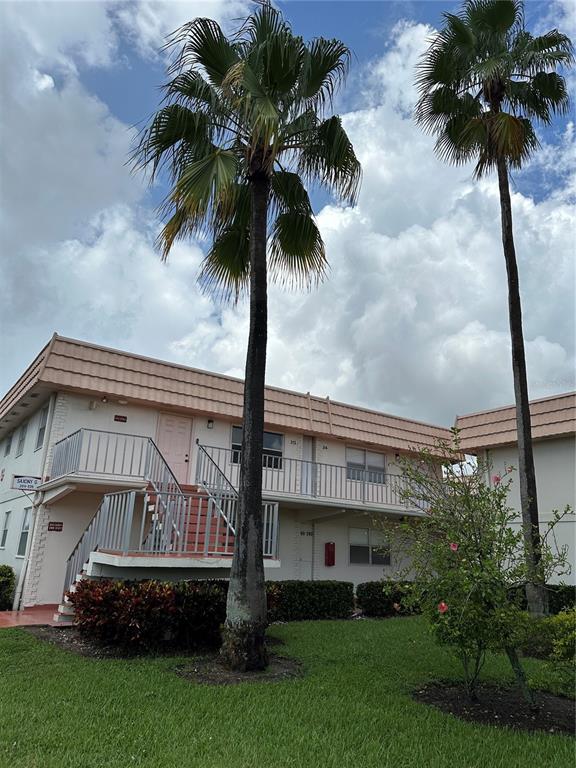 a view of a palm trees front of house with a yard