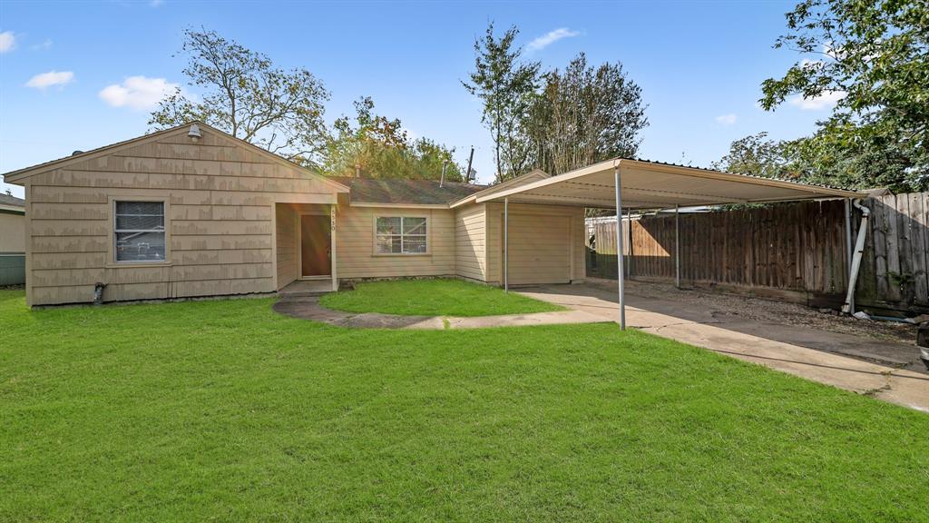 a backyard of a house with table and sofas