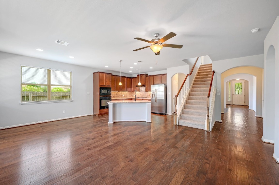 a view of entryway and kitchen with wooden floor