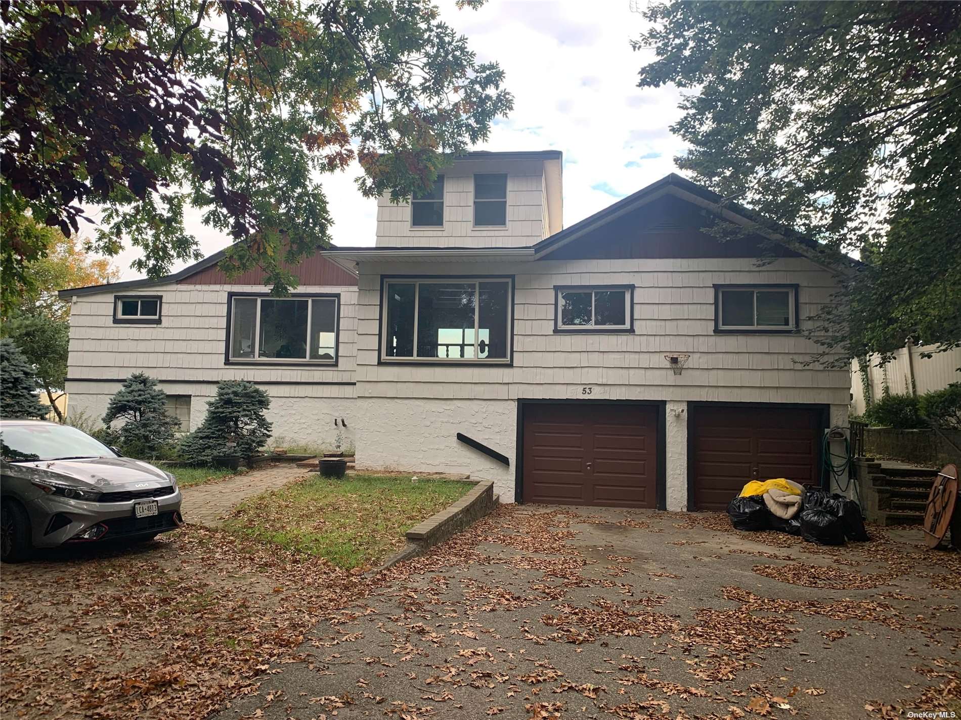 a view of a house with a yard and parking space