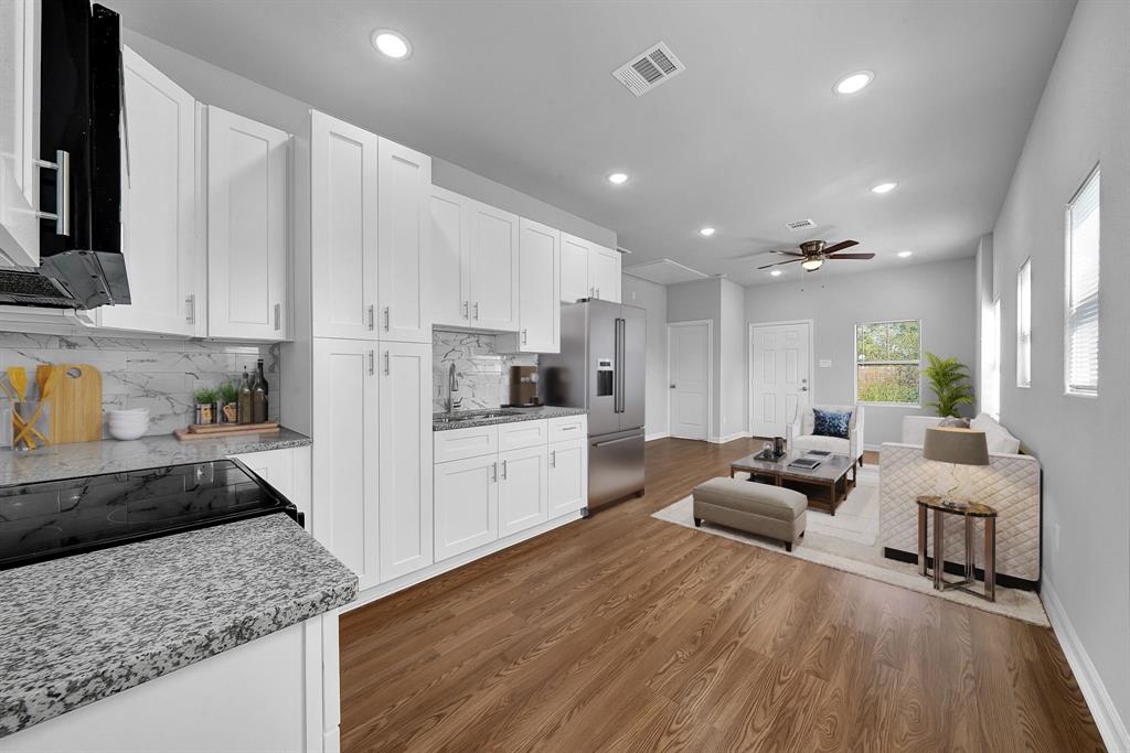 a large kitchen with stainless steel appliances lots of counter space and wooden floor