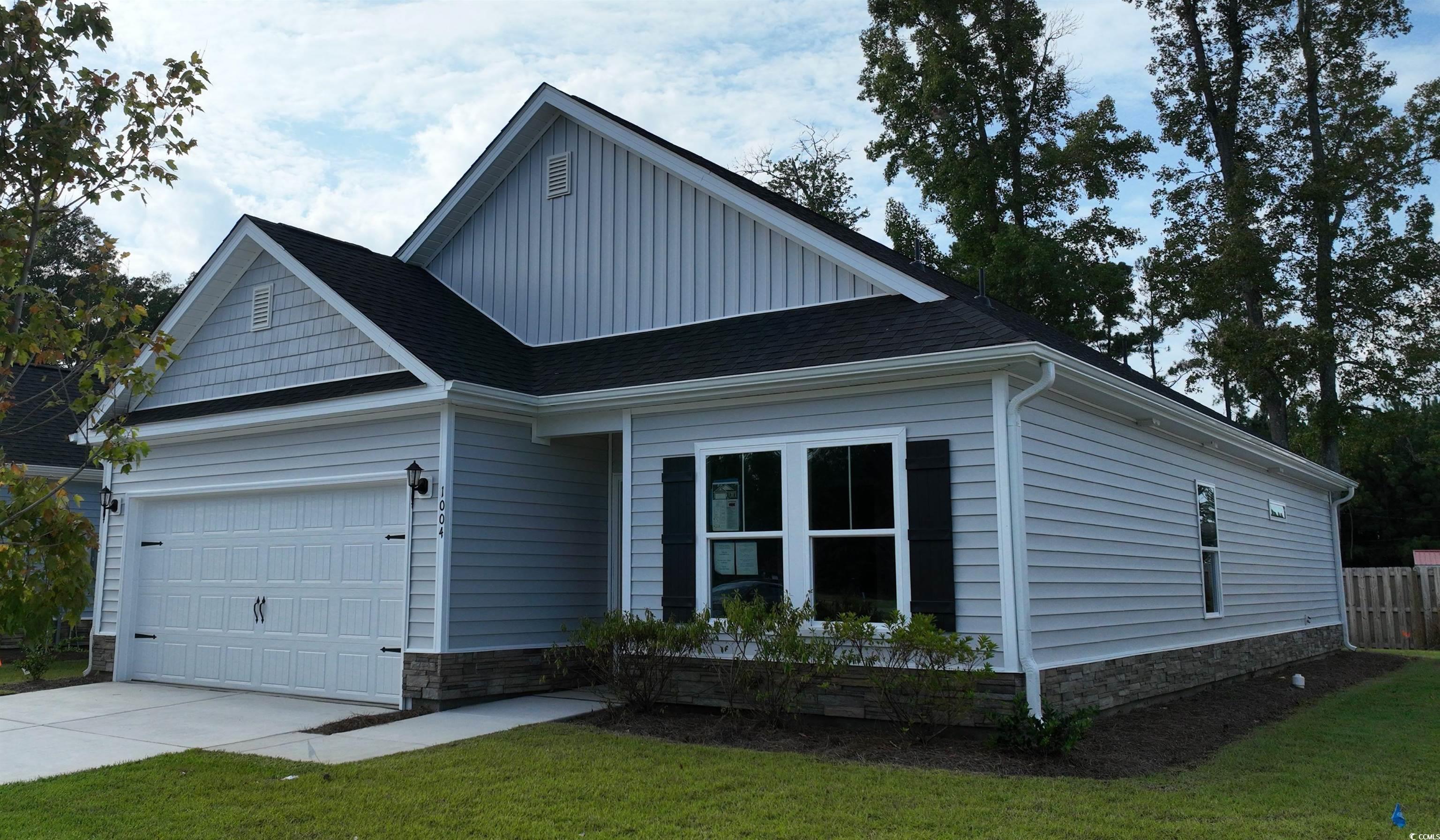 View of front facade with a front lawn and a garag