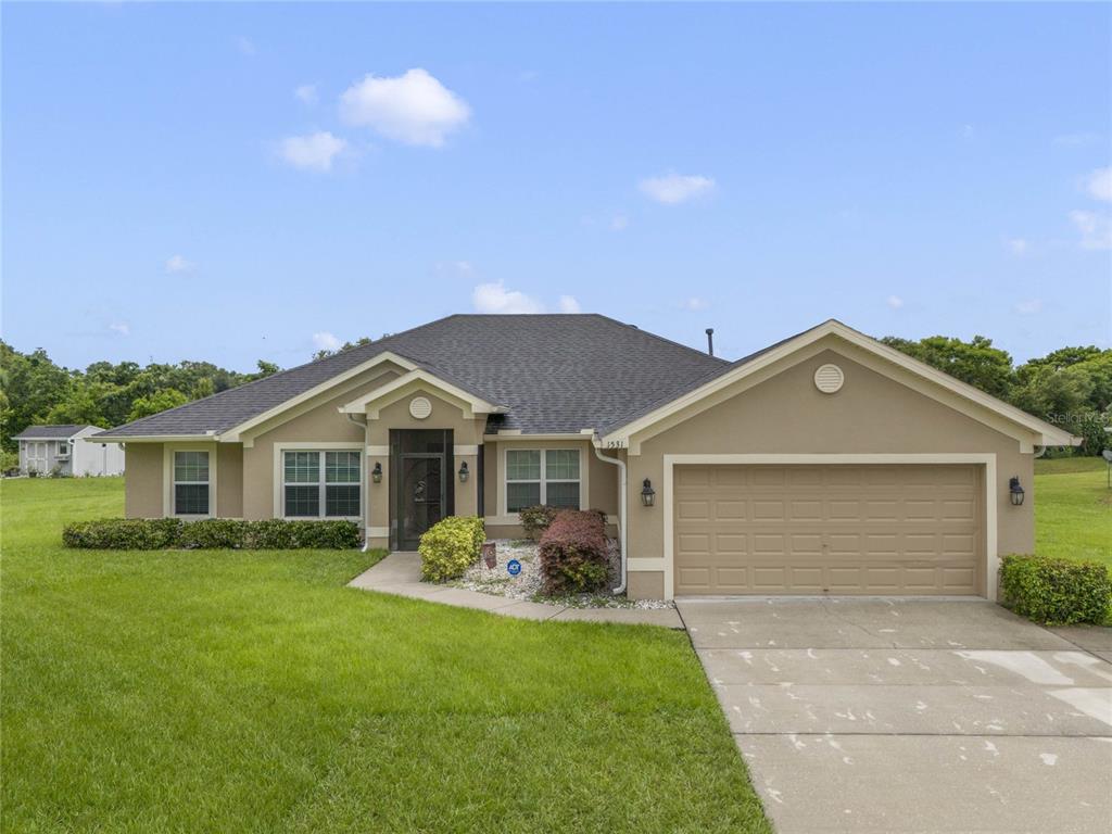 a front view of a house with a yard and garage