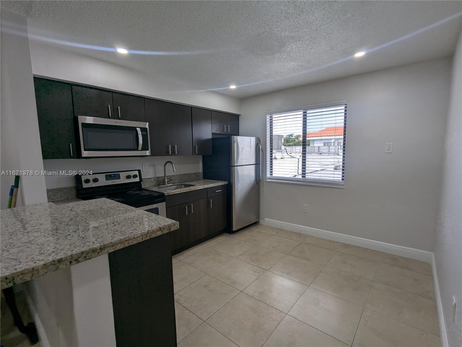 a kitchen with microwave a stove and refrigerator