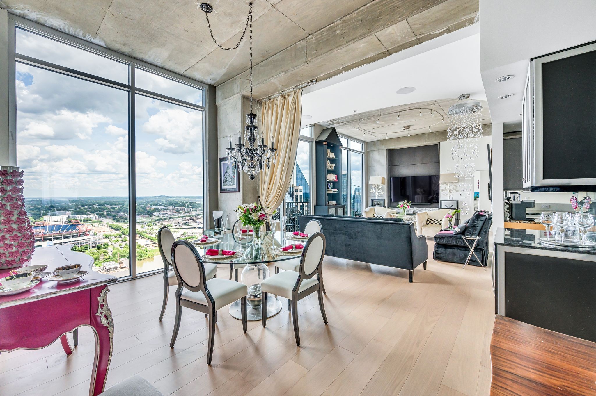 a living room with furniture a flat screen tv and a floor to ceiling window