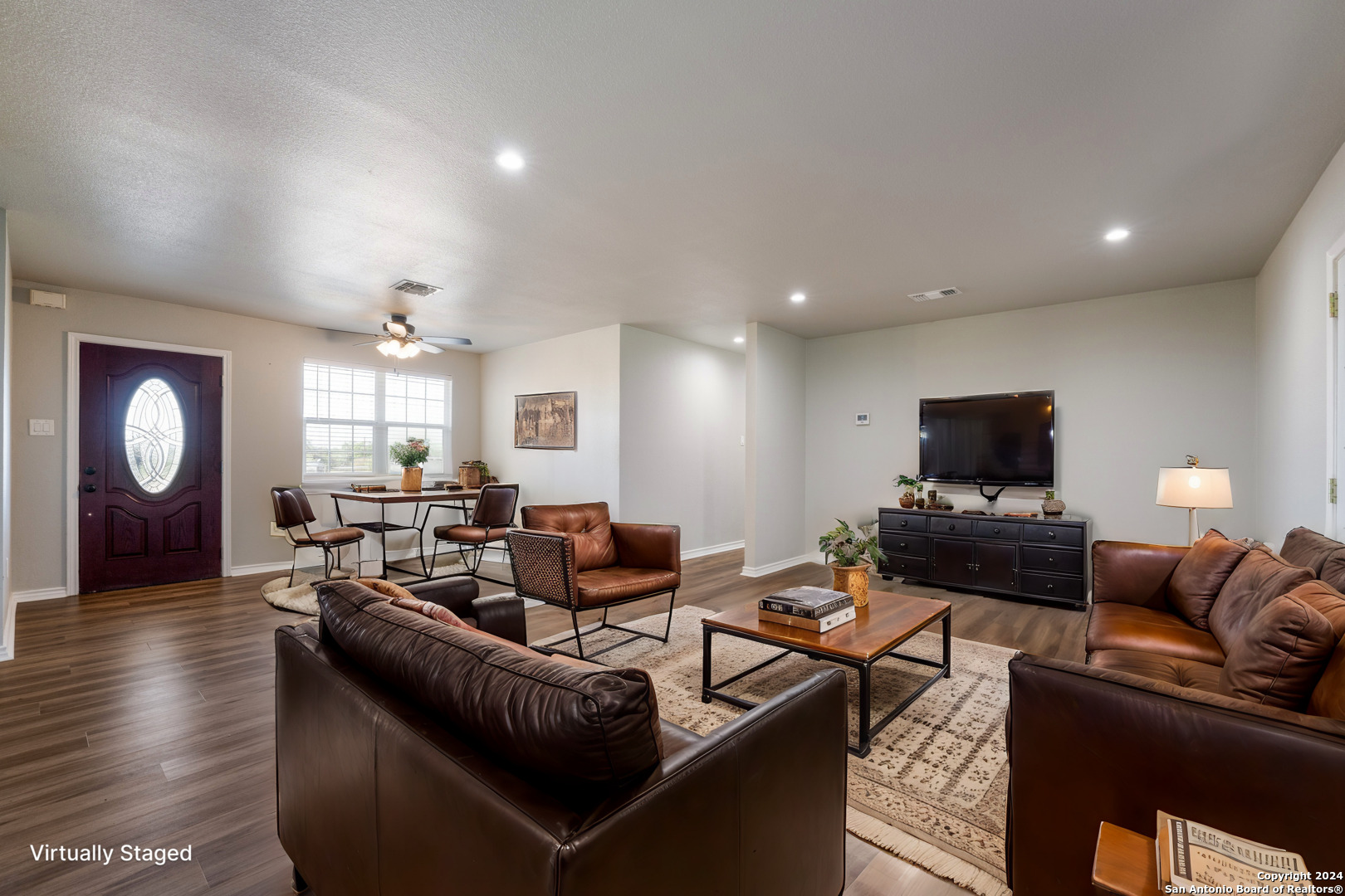 a living room with furniture and a wooden floor