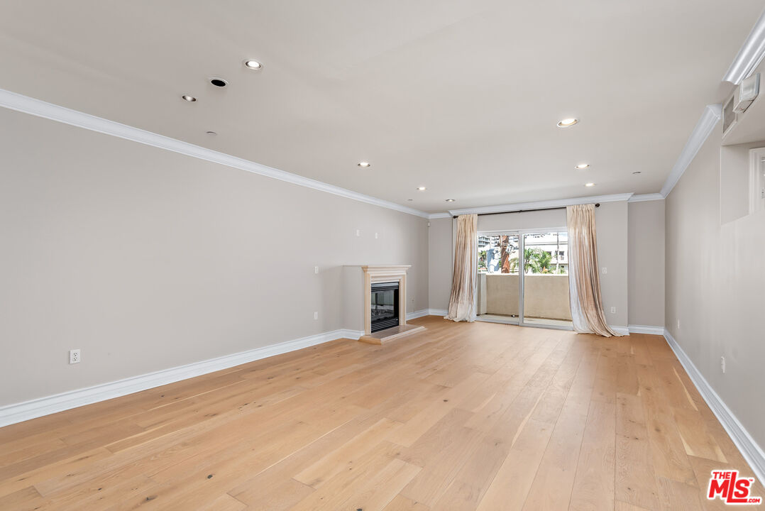 a view of a livingroom with wooden floor and staircase