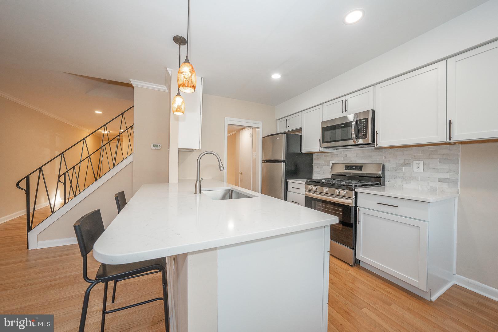 a kitchen with stainless steel appliances a stove a sink island and a refrigerator