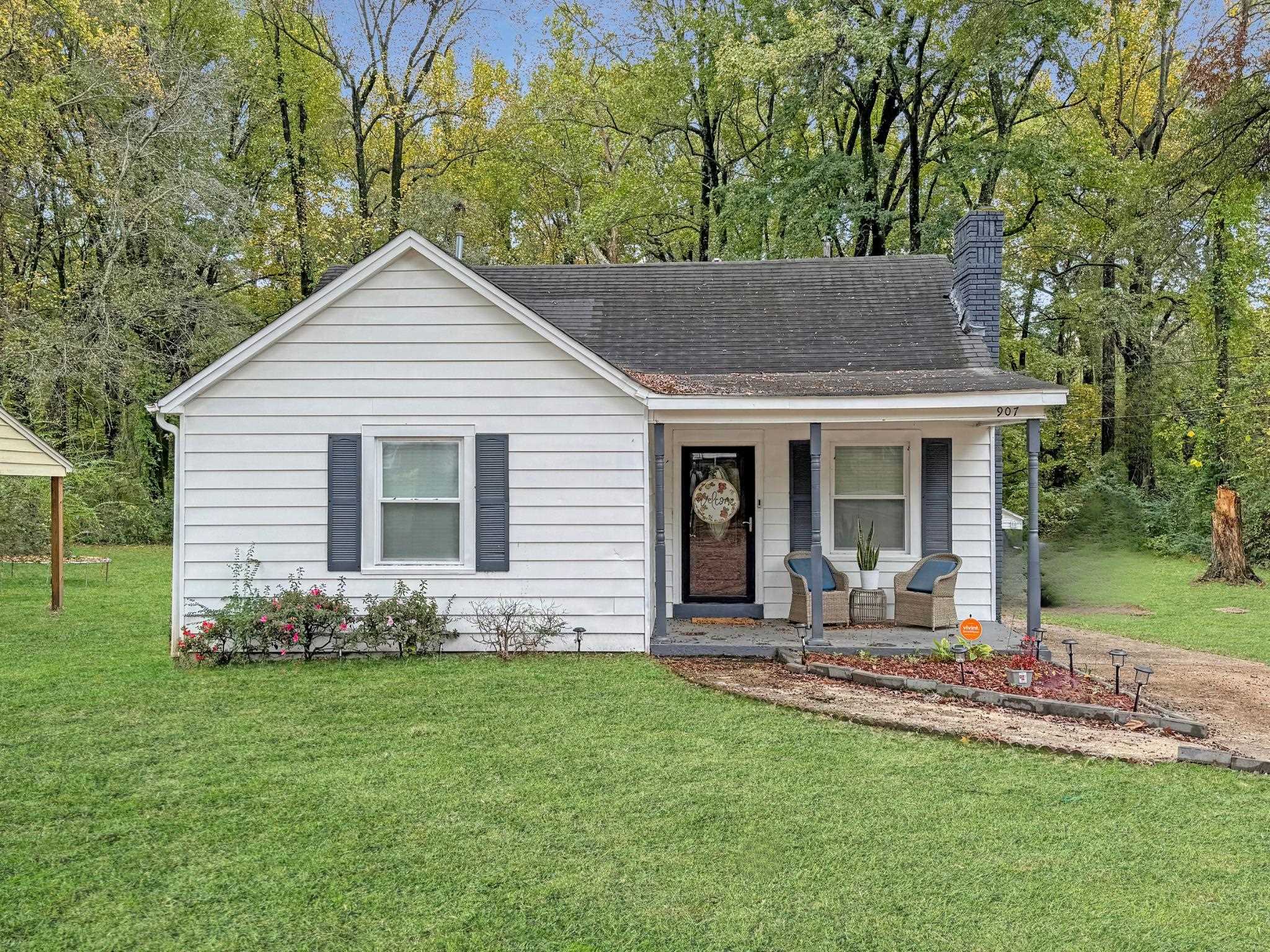 View of front facade with covered porch and a front lawn