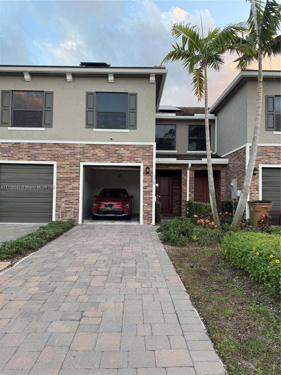 a front view of a house with a yard and a garage