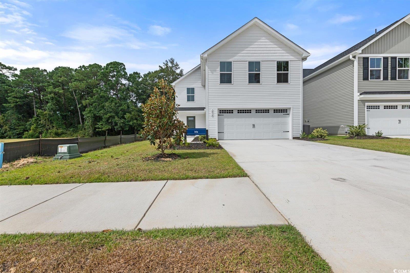 View of property featuring a garage and a front la