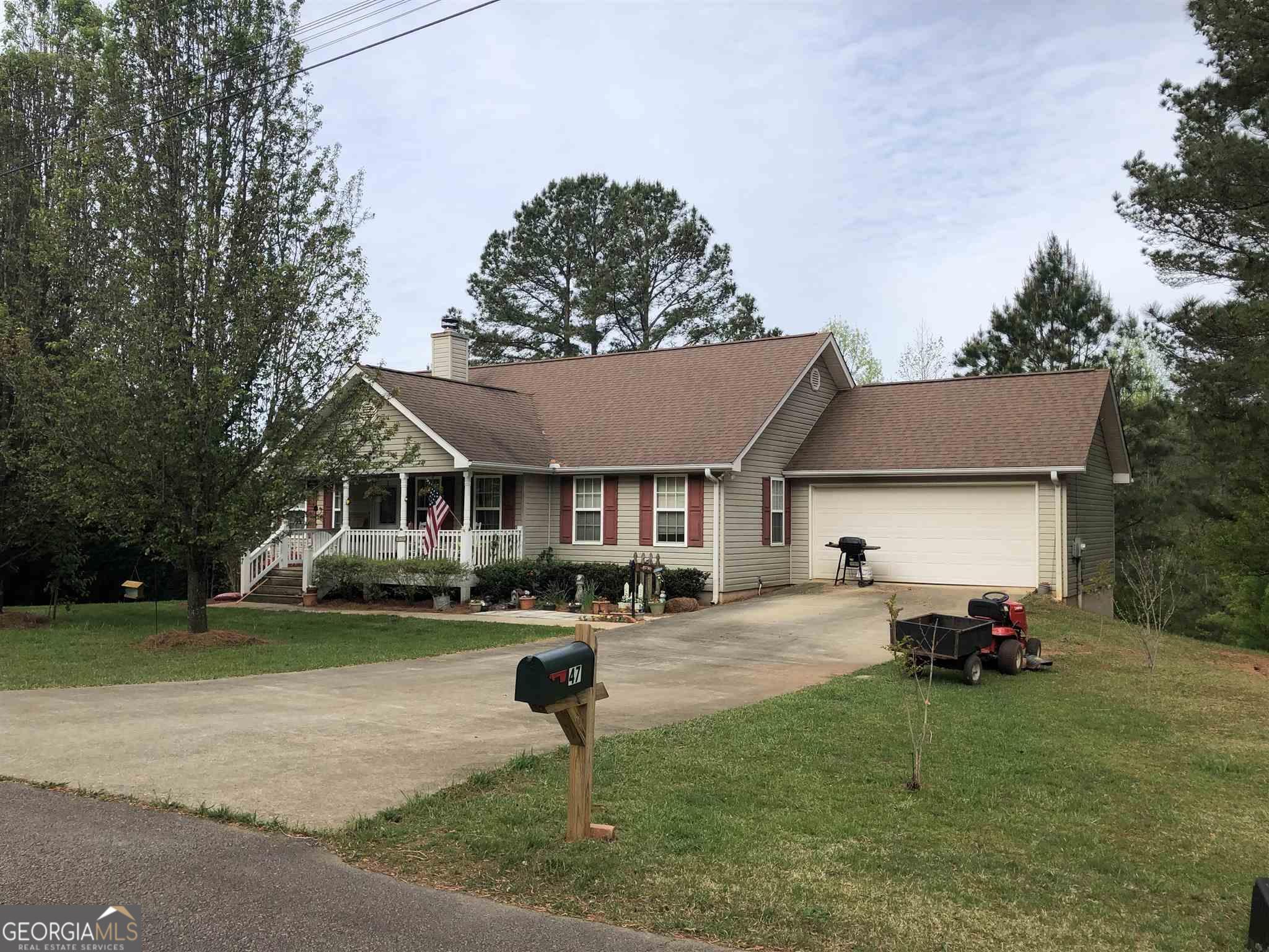 a front view of a house with a garden and trees